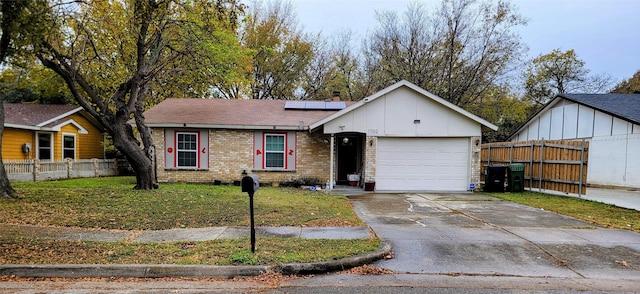 view of front facade with a front yard, solar panels, and a garage