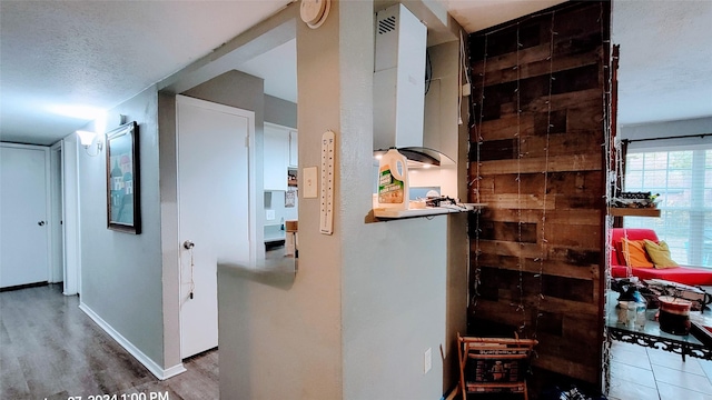 hallway with wood-type flooring and a textured ceiling