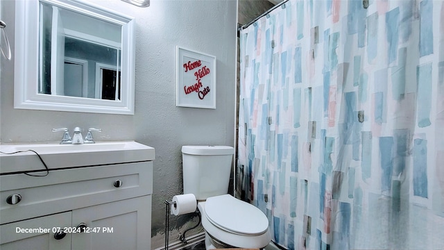 bathroom with vanity, curtained shower, and toilet