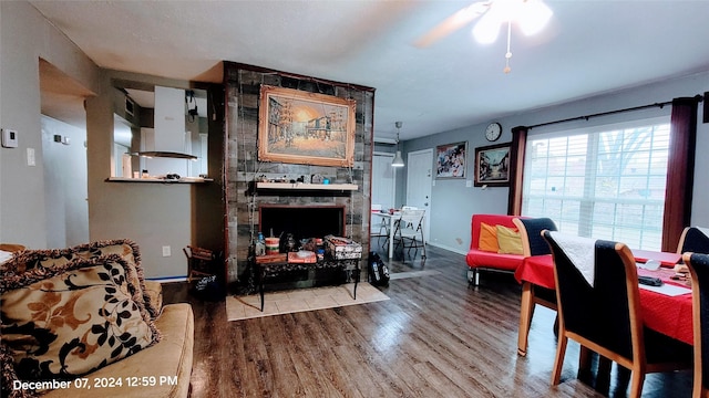 living room with hardwood / wood-style flooring, ceiling fan, and a fireplace