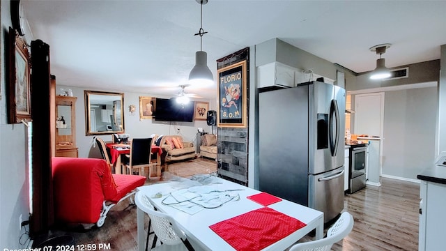 kitchen featuring appliances with stainless steel finishes, hardwood / wood-style floors, pendant lighting, white cabinets, and ceiling fan