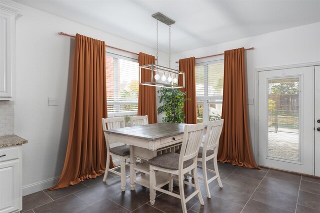 dining space featuring a wealth of natural light and an inviting chandelier