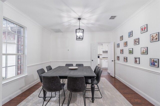 dining space featuring ornamental molding and dark hardwood / wood-style flooring