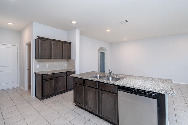 kitchen with dark brown cabinets, a kitchen island with sink, sink, light tile patterned floors, and dishwasher