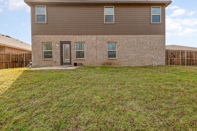 back of house with a yard and a patio