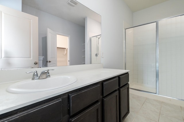 bathroom featuring vanity, an enclosed shower, and tile patterned floors