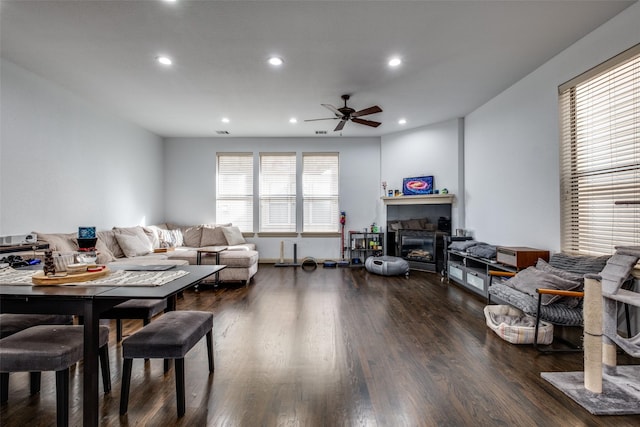 living room featuring a fireplace, ceiling fan, and dark hardwood / wood-style flooring