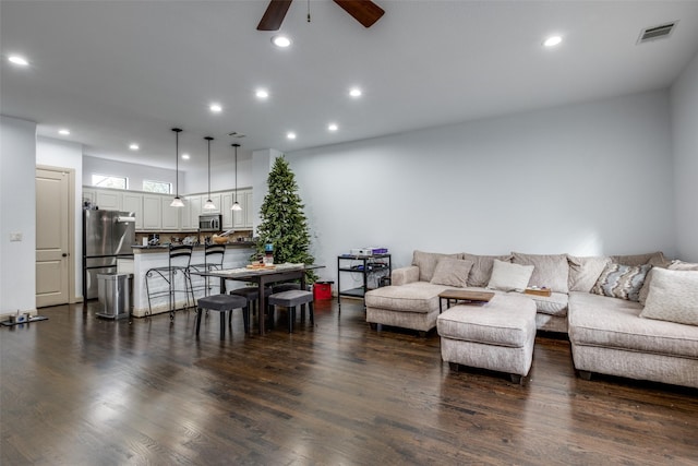 living room with ceiling fan and dark wood-type flooring