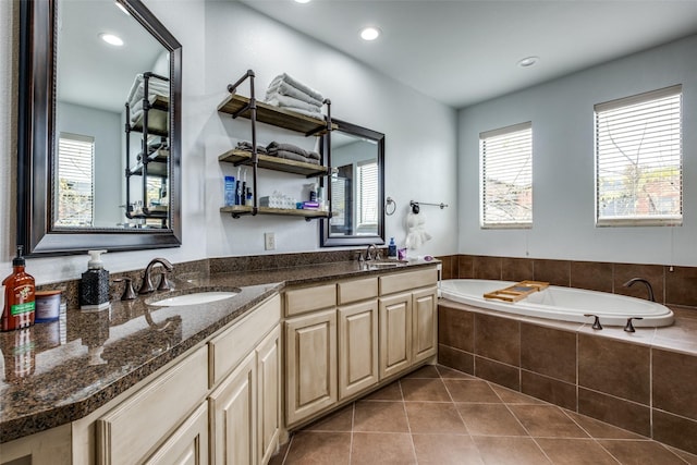 bathroom with tile patterned floors, vanity, and tiled tub