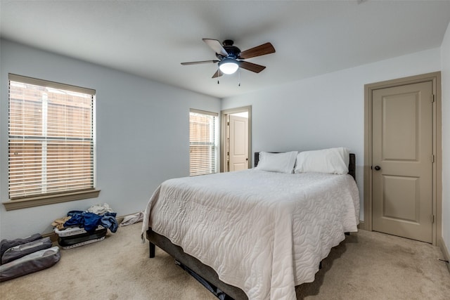 carpeted bedroom with ceiling fan and multiple windows