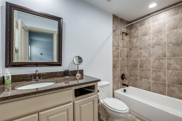 full bathroom with toilet, vanity, and tiled shower / bath