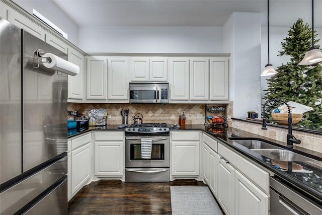 kitchen featuring decorative light fixtures, dark hardwood / wood-style floors, white cabinetry, and appliances with stainless steel finishes