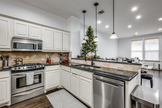 kitchen featuring pendant lighting, sink, kitchen peninsula, and stainless steel appliances