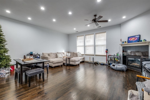 living room with ceiling fan, dark hardwood / wood-style flooring, and a tile fireplace