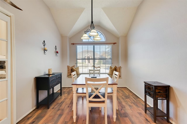 dining room featuring a chandelier, dark hardwood / wood-style flooring, and vaulted ceiling