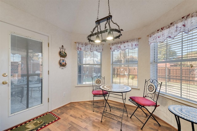 dining area with hardwood / wood-style floors and a textured ceiling