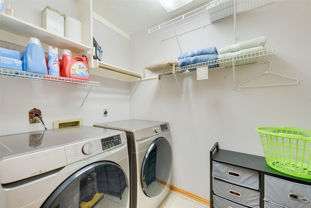 laundry area with washer and clothes dryer and a textured ceiling