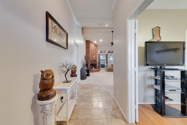 hallway with light tile patterned floors and crown molding