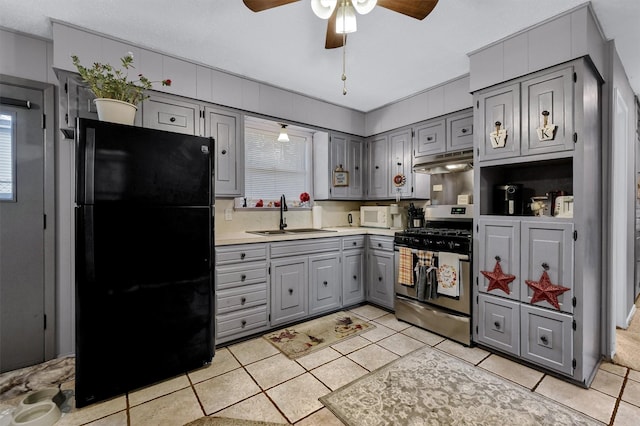 kitchen featuring gray cabinets, gas stove, black fridge, and sink