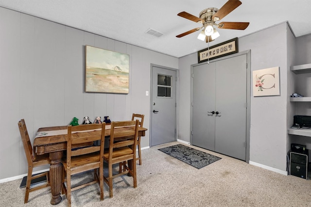 carpeted dining room featuring ceiling fan