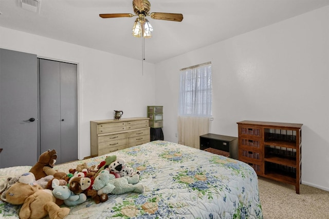 carpeted bedroom featuring ceiling fan and a closet