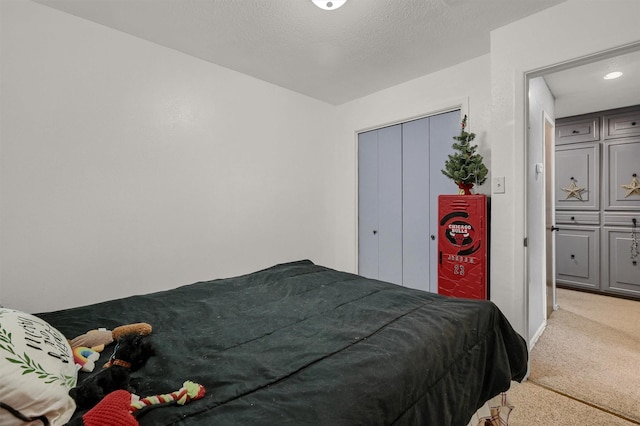 bedroom featuring light colored carpet and a textured ceiling