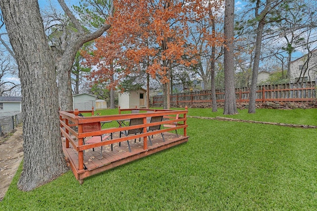 view of yard featuring a deck and a storage unit