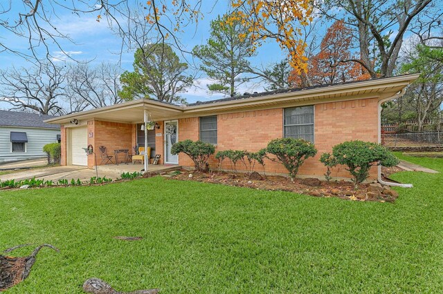 ranch-style house featuring a porch, a front yard, and a garage