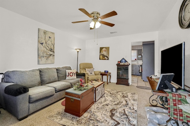 carpeted living room with ceiling fan