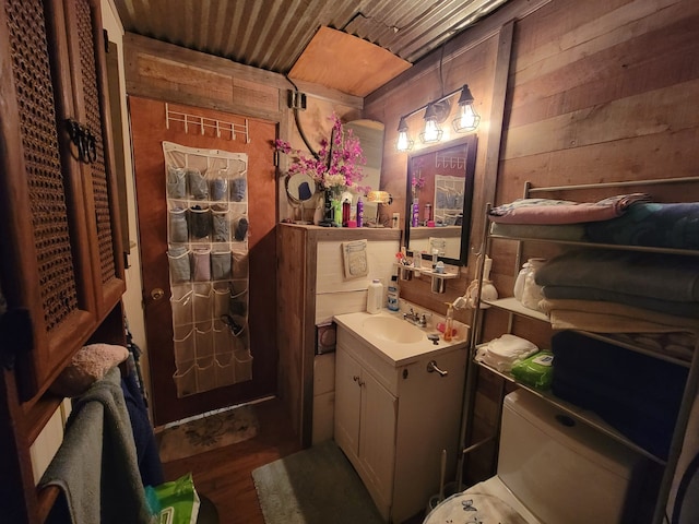 bathroom featuring vanity, wood-type flooring, wooden ceiling, and wooden walls