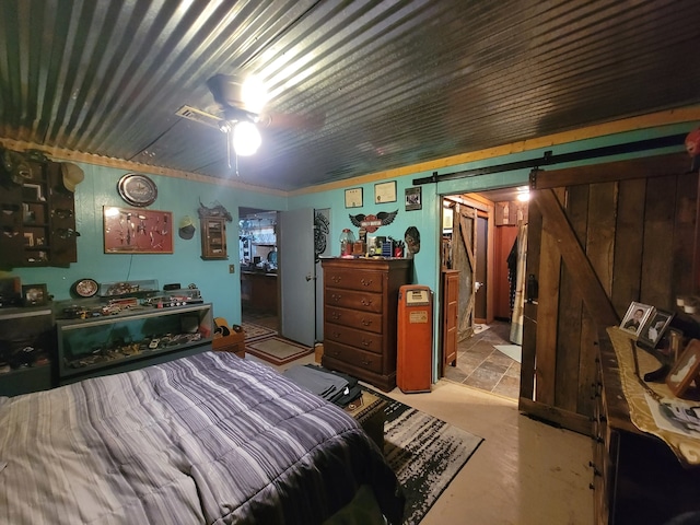 bedroom featuring a barn door and ceiling fan