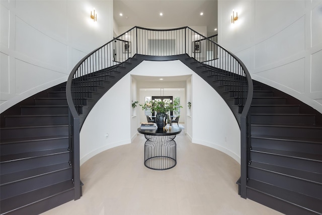 staircase featuring hardwood / wood-style flooring and a towering ceiling