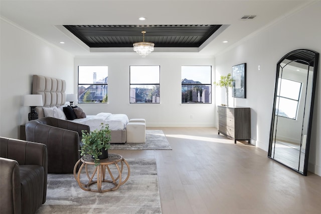 bedroom featuring a raised ceiling, crown molding, and multiple windows