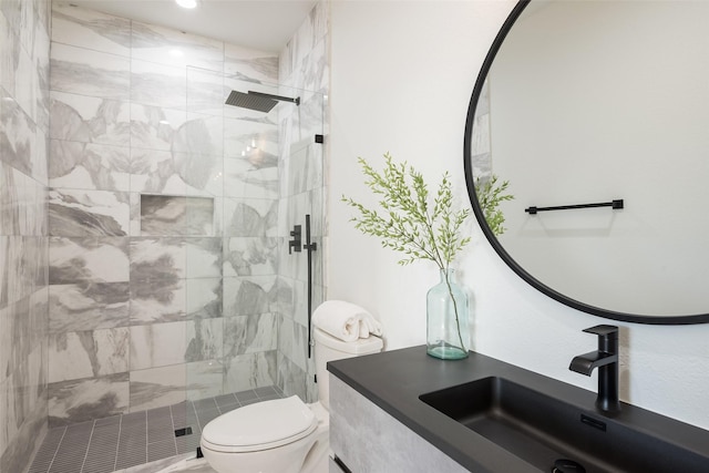 bathroom with tiled shower, toilet, and sink