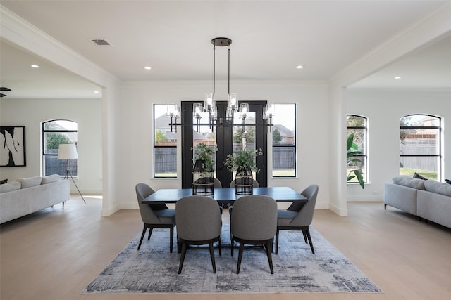 dining room featuring light hardwood / wood-style flooring, ornamental molding, and a chandelier