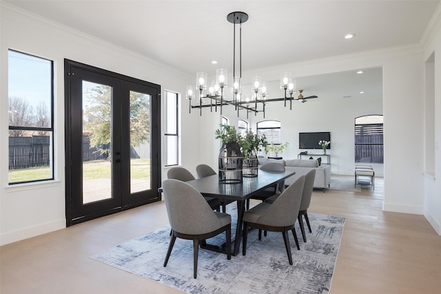 dining area featuring crown molding, light hardwood / wood-style floors, and french doors