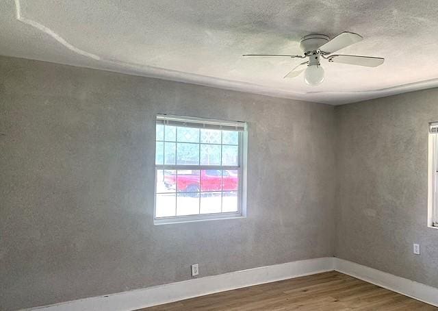 spare room featuring hardwood / wood-style floors, ceiling fan, and a textured ceiling