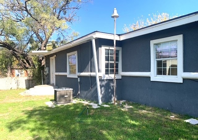 view of home's exterior with a yard and central AC unit