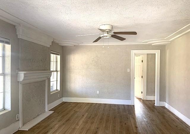 unfurnished living room with ceiling fan, dark hardwood / wood-style floors, and a textured ceiling