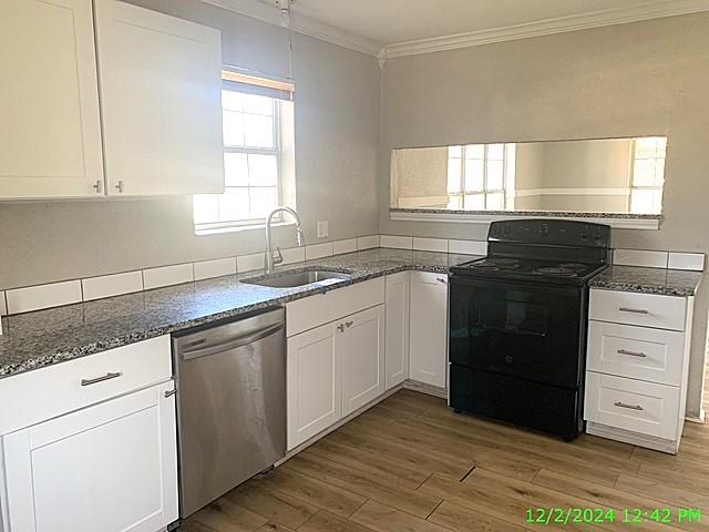 kitchen with black range with electric stovetop, white cabinetry, dishwasher, and light hardwood / wood-style floors