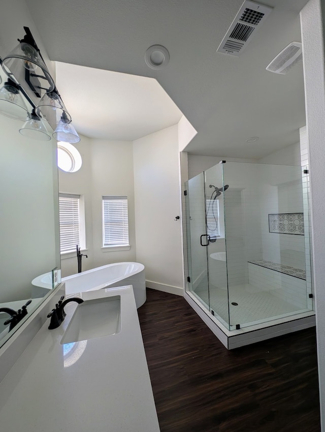 bathroom with independent shower and bath, sink, and hardwood / wood-style floors