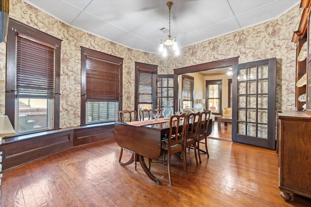 dining area featuring hardwood / wood-style floors and an inviting chandelier