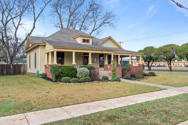 bungalow-style house featuring covered porch and a front yard