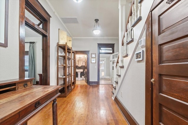 foyer featuring crown molding and light hardwood / wood-style flooring