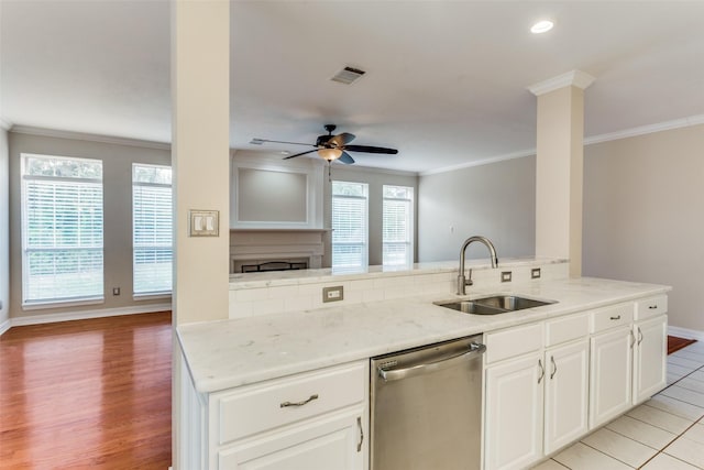 kitchen featuring light stone countertops, dishwasher, white cabinets, and sink