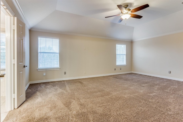 unfurnished room featuring light colored carpet, vaulted ceiling, plenty of natural light, and crown molding