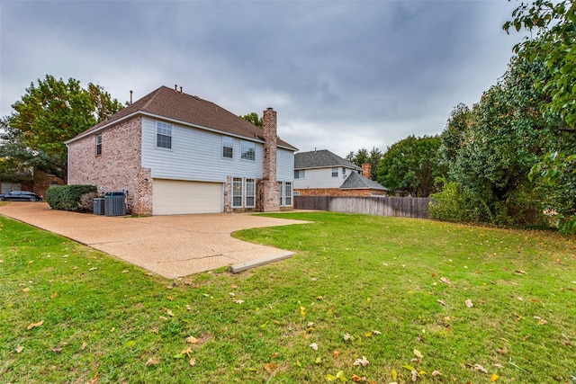 back of house with a patio, a yard, and a garage