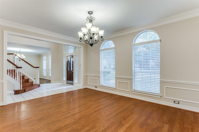 interior space with ornamental molding, light hardwood / wood-style floors, and a notable chandelier