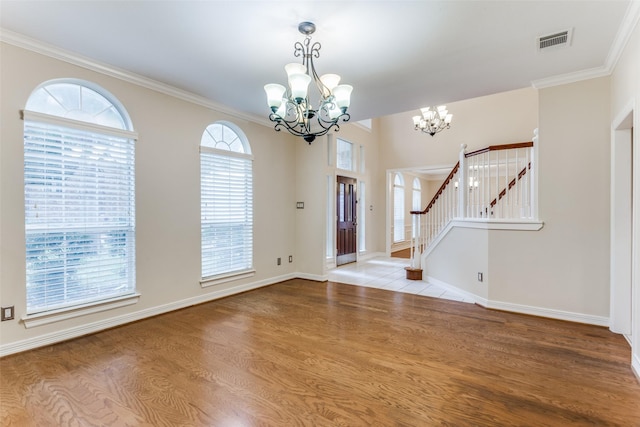 entryway featuring ornamental molding, a notable chandelier, and light wood-type flooring