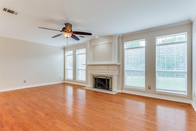 unfurnished living room with light hardwood / wood-style floors, plenty of natural light, crown molding, and ceiling fan